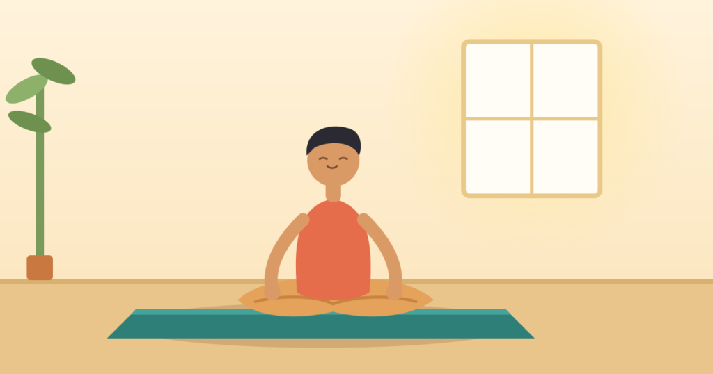 Beginner seated in easy pose on a yoga mat in a bright room