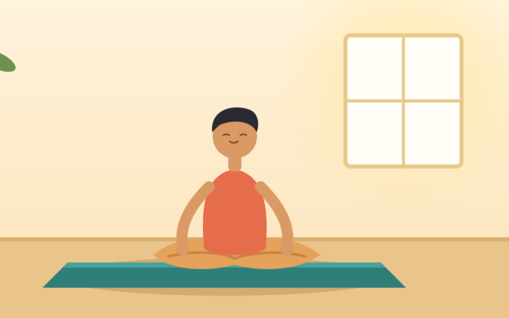 Beginner seated in easy pose on a yoga mat in a bright room